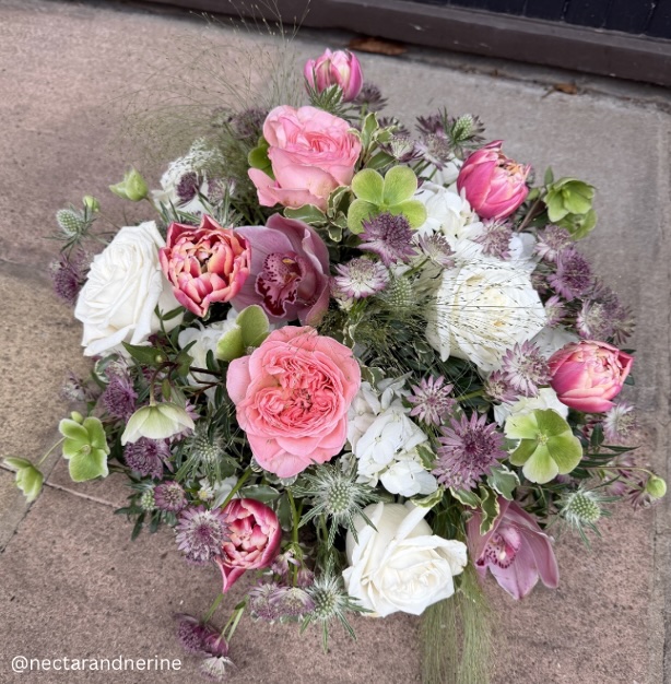 Round posy pad arrangement with pink, white, green and mauve flowers