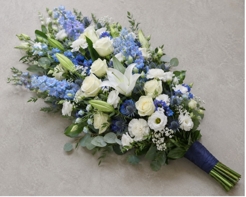 Large flat hand-tied sheath arrangement with blue and white flowers